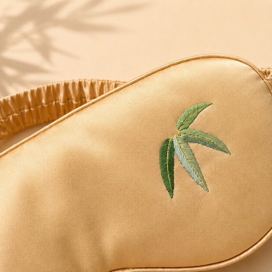 Close-up of bamboo-leaf embroidery on a Champagne mulberry silk sleep mask