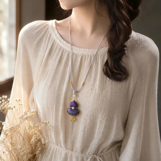 Woman wearing a purple Song Brocade gourd pendant necklace with woven cord