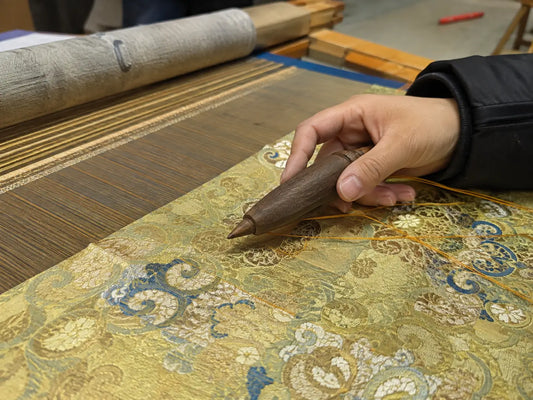 Artisan hand finishing a detailed patterned textile by hand