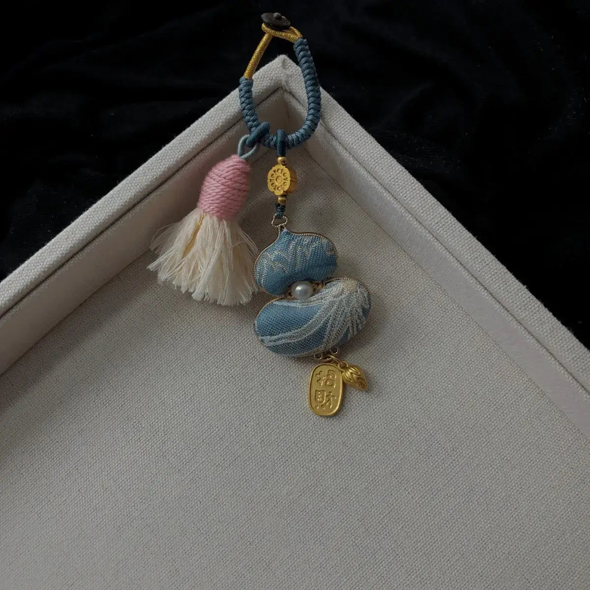 Blue textile gourd bag charm with floral detail and tassel
