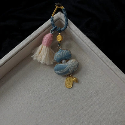 Blue textile gourd bag charm with floral detail and tassel