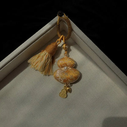 Yellow textile gourd bag charm with floral detail and tassel