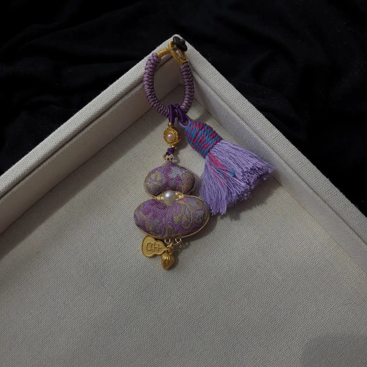 Purple patterned textile gourd bag charm with decorative tassel