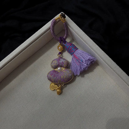 Purple patterned textile gourd bag charm with decorative tassel