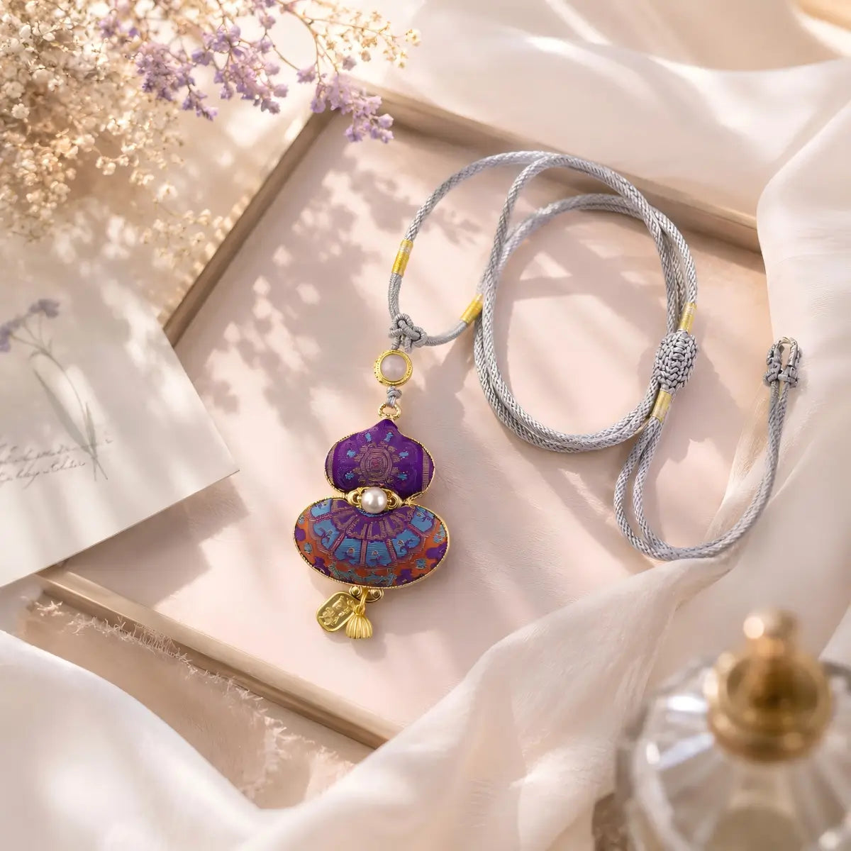Purple Song Brocade gourd pendant shown flat with a handwoven cord
