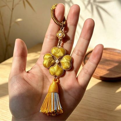 Handmade four-leaf clover bag charms shown by hand in different color designs